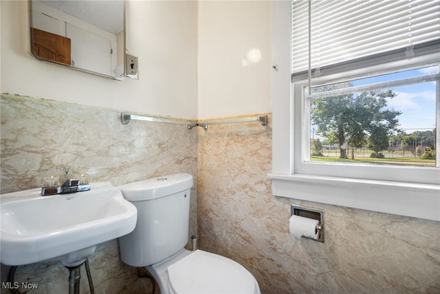 bathroom with tile walls and toilet