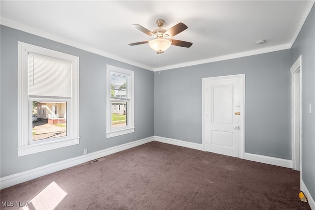 unfurnished room featuring ceiling fan, dark colored carpet, and ornamental molding