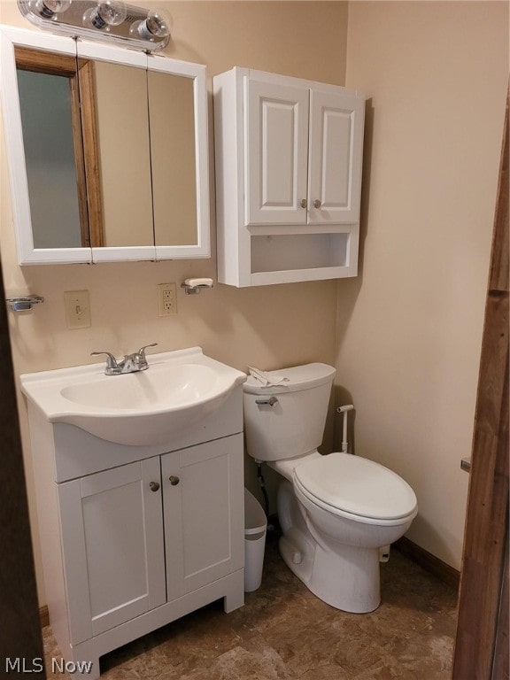 bathroom with toilet, vanity, and tile patterned floors