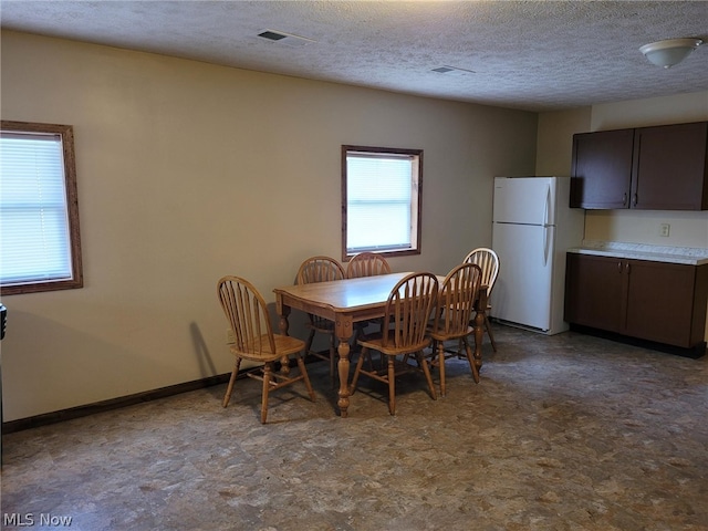 dining space featuring tile patterned floors and a textured ceiling