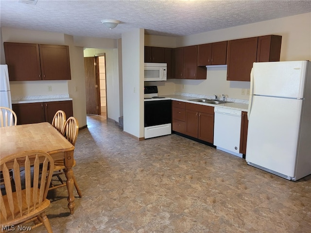 kitchen with sink, tile patterned floors, a textured ceiling, and white appliances