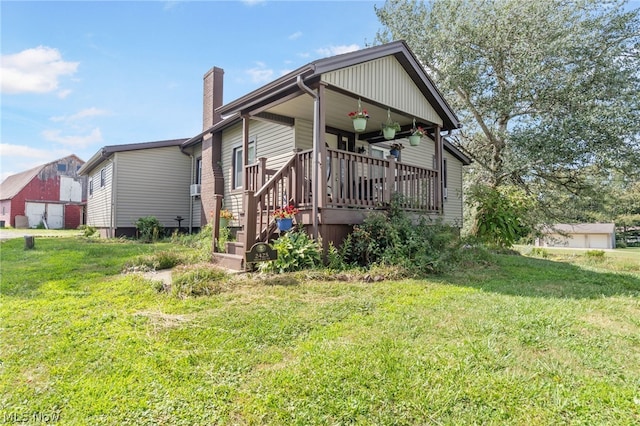 back of house with a deck and a lawn