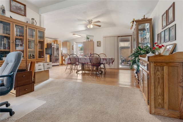 carpeted home office with ceiling fan and vaulted ceiling