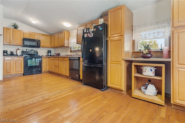 kitchen featuring light hardwood / wood-style flooring, black appliances, and vaulted ceiling