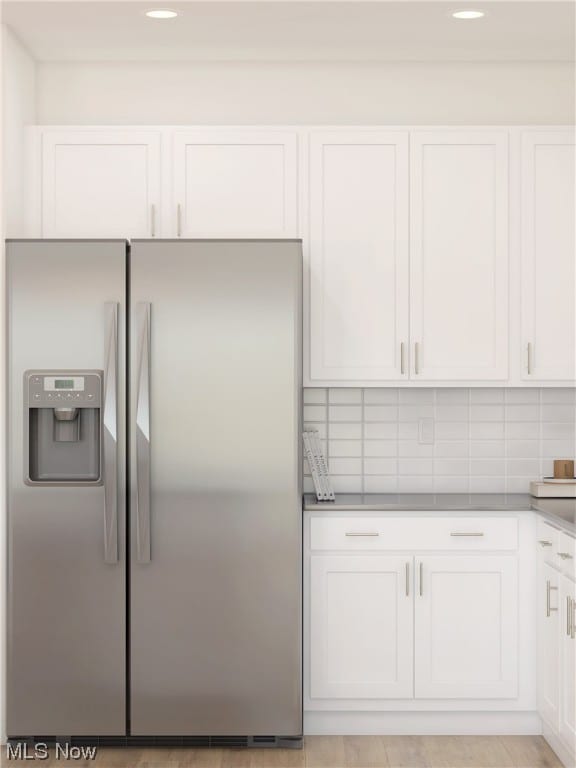 kitchen featuring white cabinetry, stainless steel fridge, and tasteful backsplash