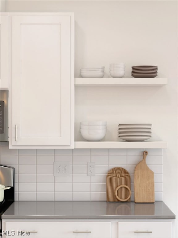 room details featuring white cabinetry and tasteful backsplash