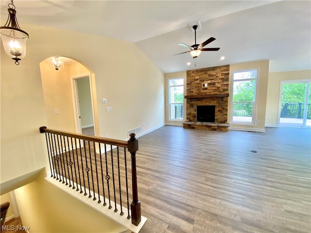 living room with wood-type flooring, a fireplace, lofted ceiling, and ceiling fan