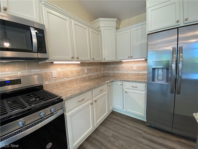 kitchen featuring white cabinets, tasteful backsplash, appliances with stainless steel finishes, light stone countertops, and dark hardwood / wood-style flooring