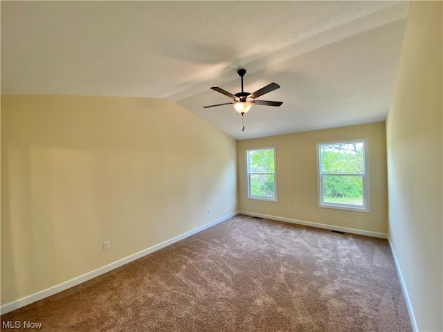 empty room with vaulted ceiling, ceiling fan, carpet, and baseboards