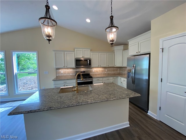 kitchen with tasteful backsplash, lofted ceiling, appliances with stainless steel finishes, white cabinetry, and a sink