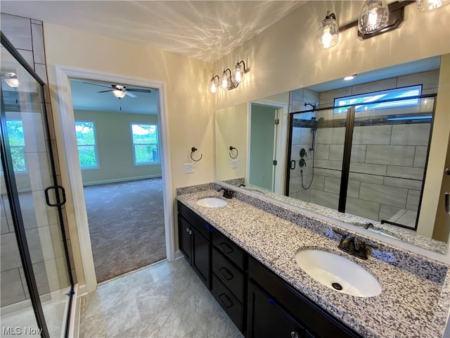 bathroom featuring a stall shower, a sink, baseboards, and double vanity