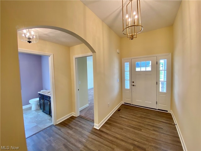 entryway featuring an inviting chandelier and dark hardwood / wood-style flooring