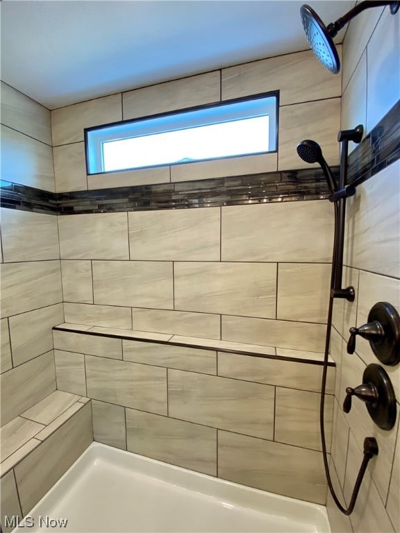 bathroom featuring tiled shower and a healthy amount of sunlight