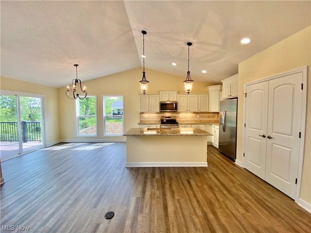 kitchen featuring decorative light fixtures, an island with sink, appliances with stainless steel finishes, and white cabinetry