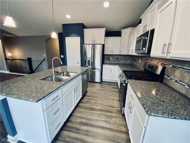 kitchen featuring dark wood-style floors, stainless steel appliances, decorative backsplash, white cabinetry, and a sink