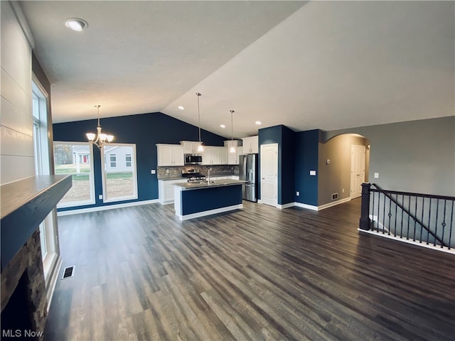 kitchen featuring dark wood-type flooring, visible vents, open floor plan, appliances with stainless steel finishes, and an inviting chandelier