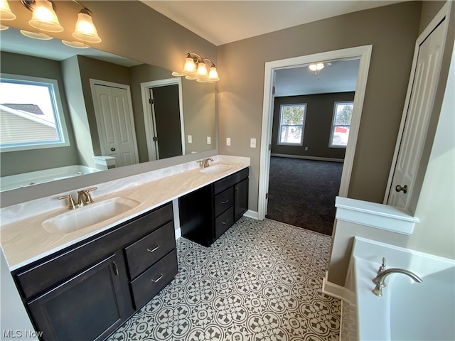 bathroom with a garden tub, a sink, baseboards, and double vanity