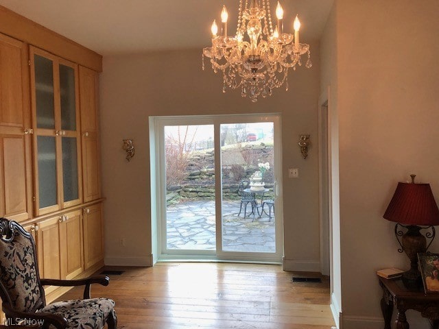 entryway featuring an inviting chandelier and light hardwood / wood-style floors