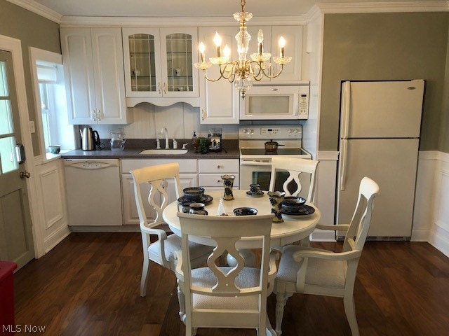 kitchen featuring white appliances, white cabinetry, dark hardwood / wood-style floors, and decorative light fixtures