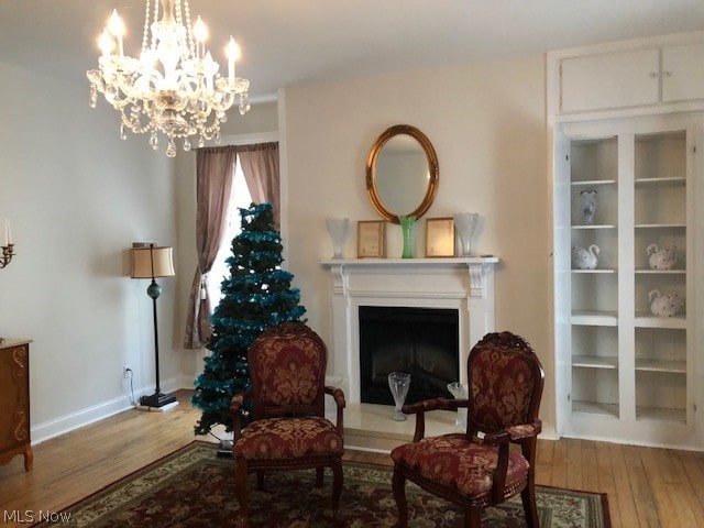 living area with a notable chandelier and hardwood / wood-style flooring