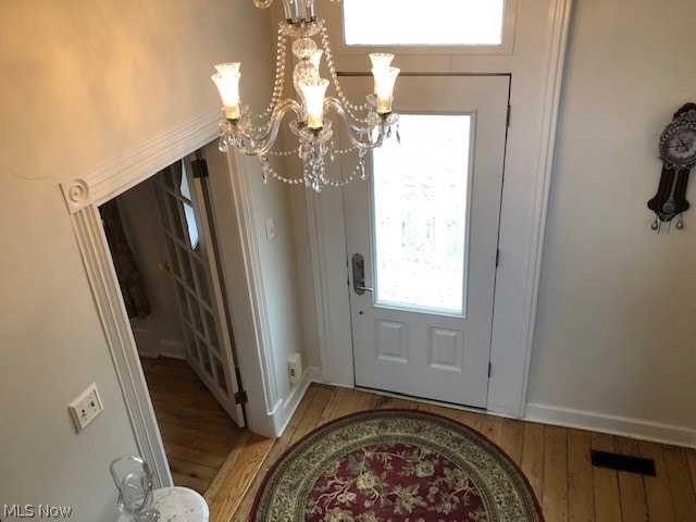 entryway featuring an inviting chandelier and light hardwood / wood-style flooring