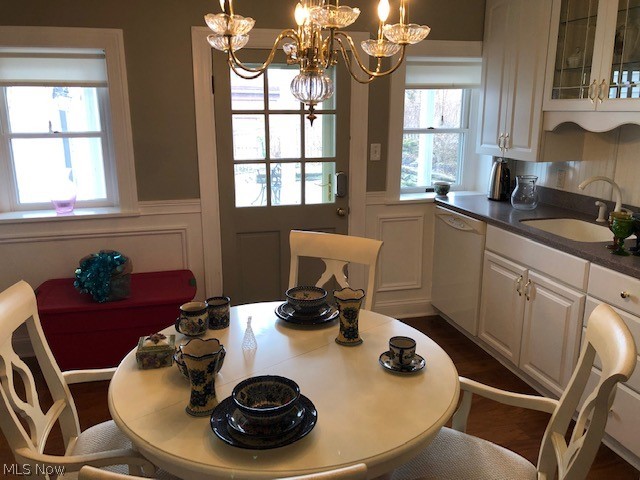 dining space with sink and a notable chandelier