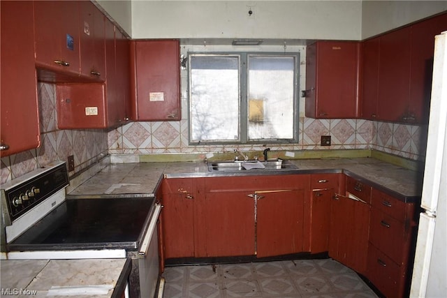 kitchen with range with electric cooktop, decorative backsplash, sink, and white fridge