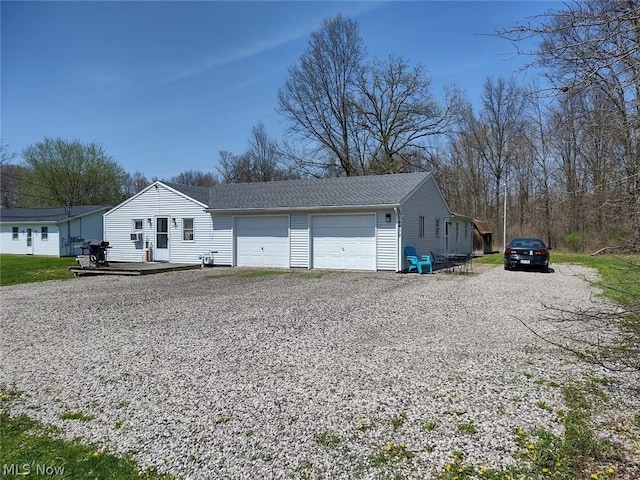 view of front of house featuring a garage, gravel driveway, and a deck
