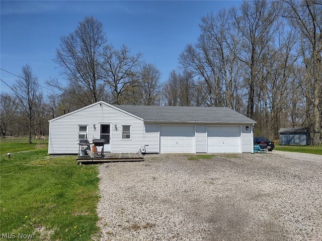 view of front of home featuring a garage, a shed, and a front yard