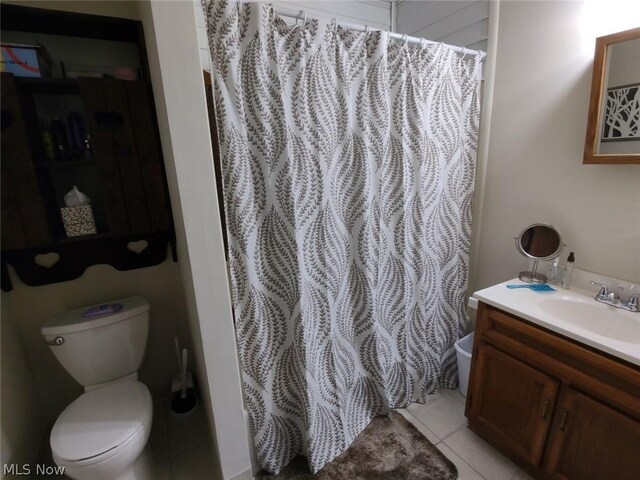 bathroom with tile patterned flooring, vanity, and toilet