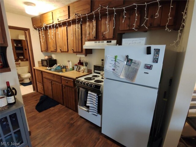 kitchen with white appliances, sink, and dark wood-type flooring