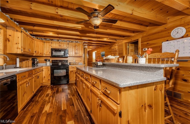 kitchen with a kitchen island, dark hardwood / wood-style floors, black appliances, beam ceiling, and sink