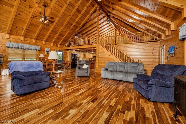 living room featuring beamed ceiling, wooden ceiling, wood-type flooring, ceiling fan, and wooden walls