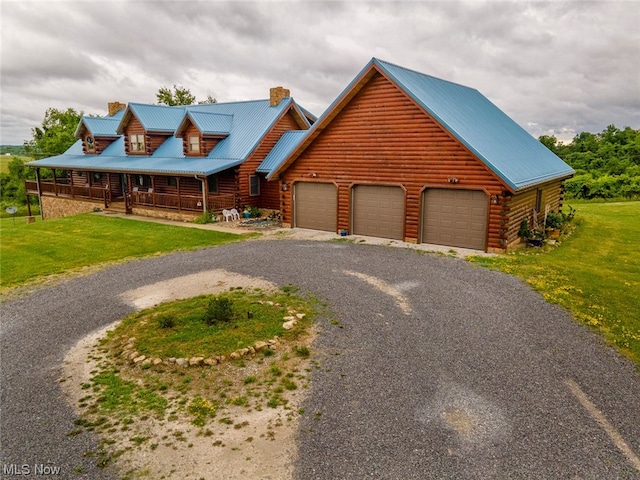 log cabin featuring a garage, covered porch, and a front yard