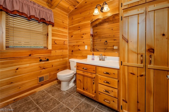 bathroom featuring wooden walls, tile patterned floors, toilet, lofted ceiling, and vanity