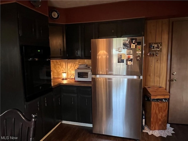 911 Grandview Ave, New Matamoras, OH 45767 - kitchen with oven, dark cabinetry, dark wood finished floors, freestanding refrigerator, and white microwave