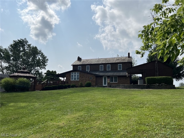 rear view of property with a gazebo and a lawn