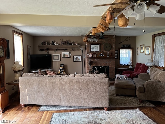 living room featuring ceiling fan, wood-type flooring, and a wealth of natural light