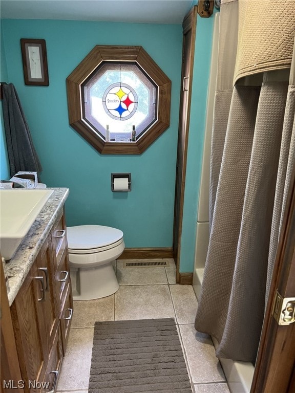 bathroom featuring vanity, tile patterned flooring, and toilet