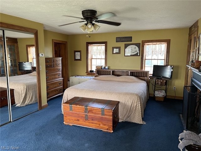 carpeted bedroom featuring a textured ceiling and ceiling fan