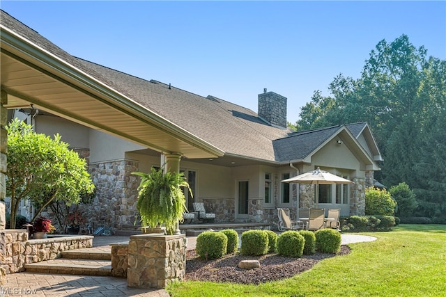 rear view of property with a lawn and a patio