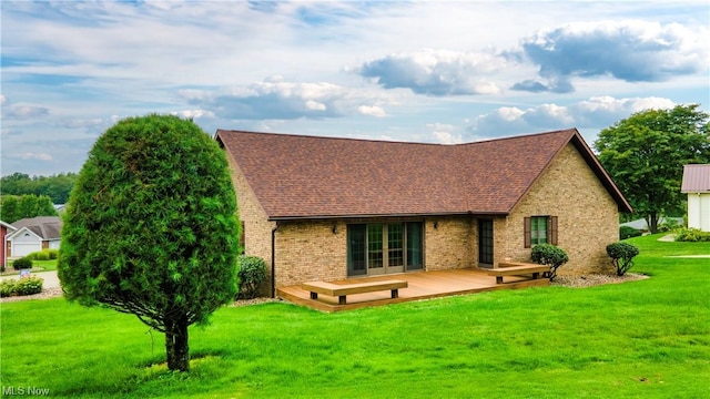 back of property with a deck and a lawn