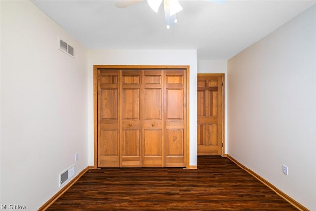 unfurnished bedroom featuring ceiling fan and dark hardwood / wood-style flooring