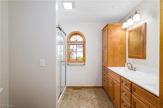 bathroom with vanity and a shower with door