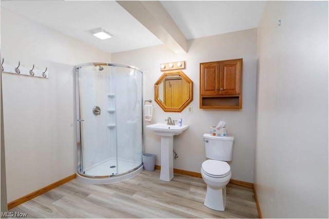 bathroom with hardwood / wood-style flooring, toilet, and walk in shower