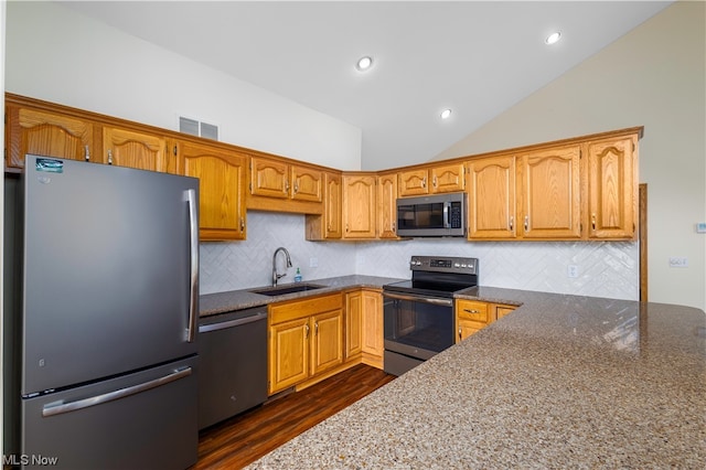 kitchen featuring tasteful backsplash, sink, dark stone counters, and stainless steel appliances