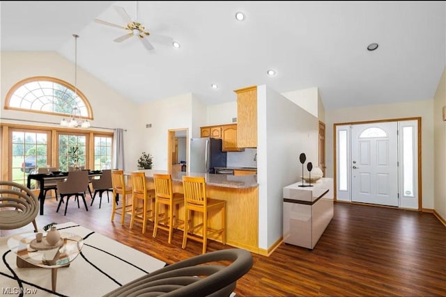 living room featuring ceiling fan, dark hardwood / wood-style flooring, and vaulted ceiling