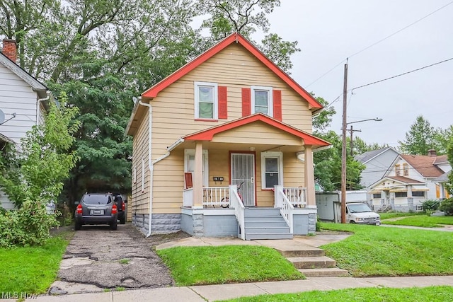 view of front of house with a porch and a front lawn