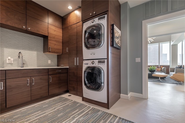 laundry room with stacked washer / drying machine and sink