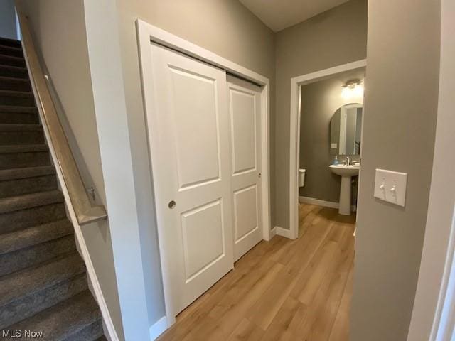 hallway featuring sink and light wood-type flooring